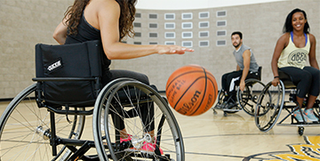 People in wheelchairs playing basketball